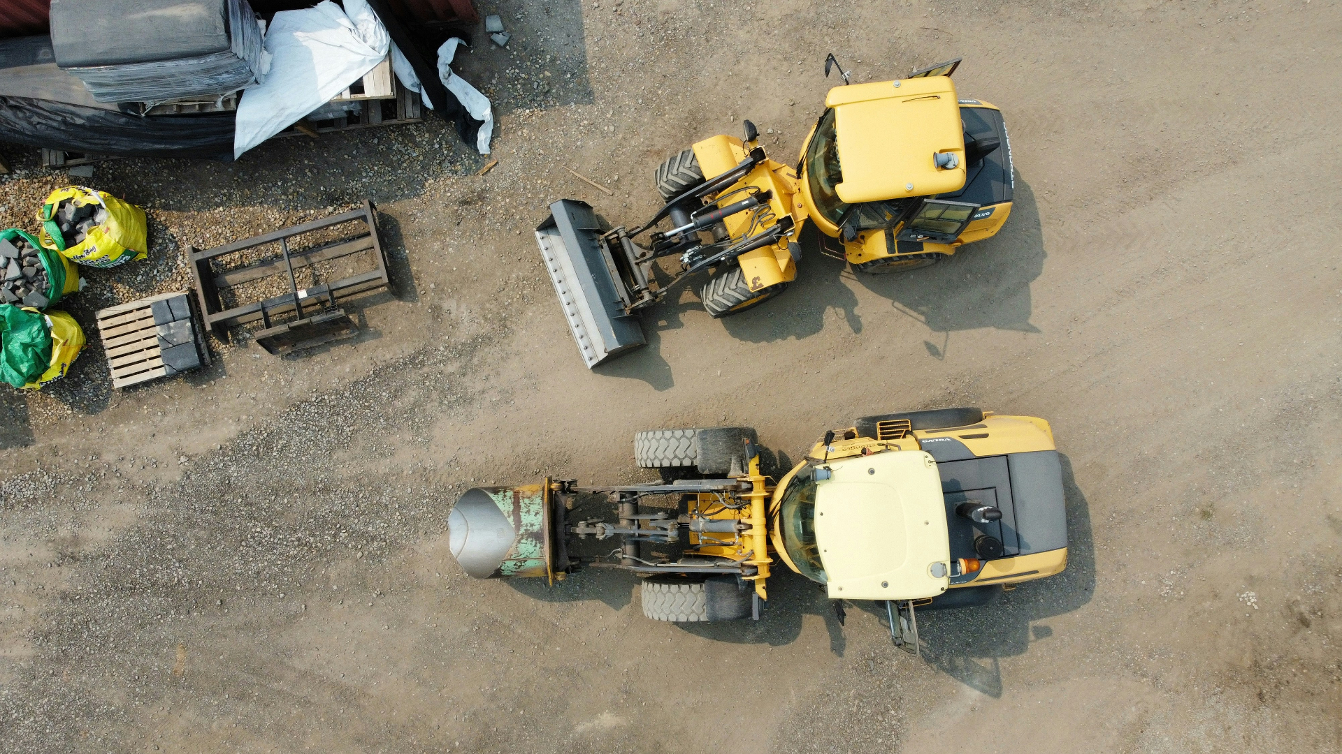 Overhead view of wheel loaders working an industrial gravel lot
